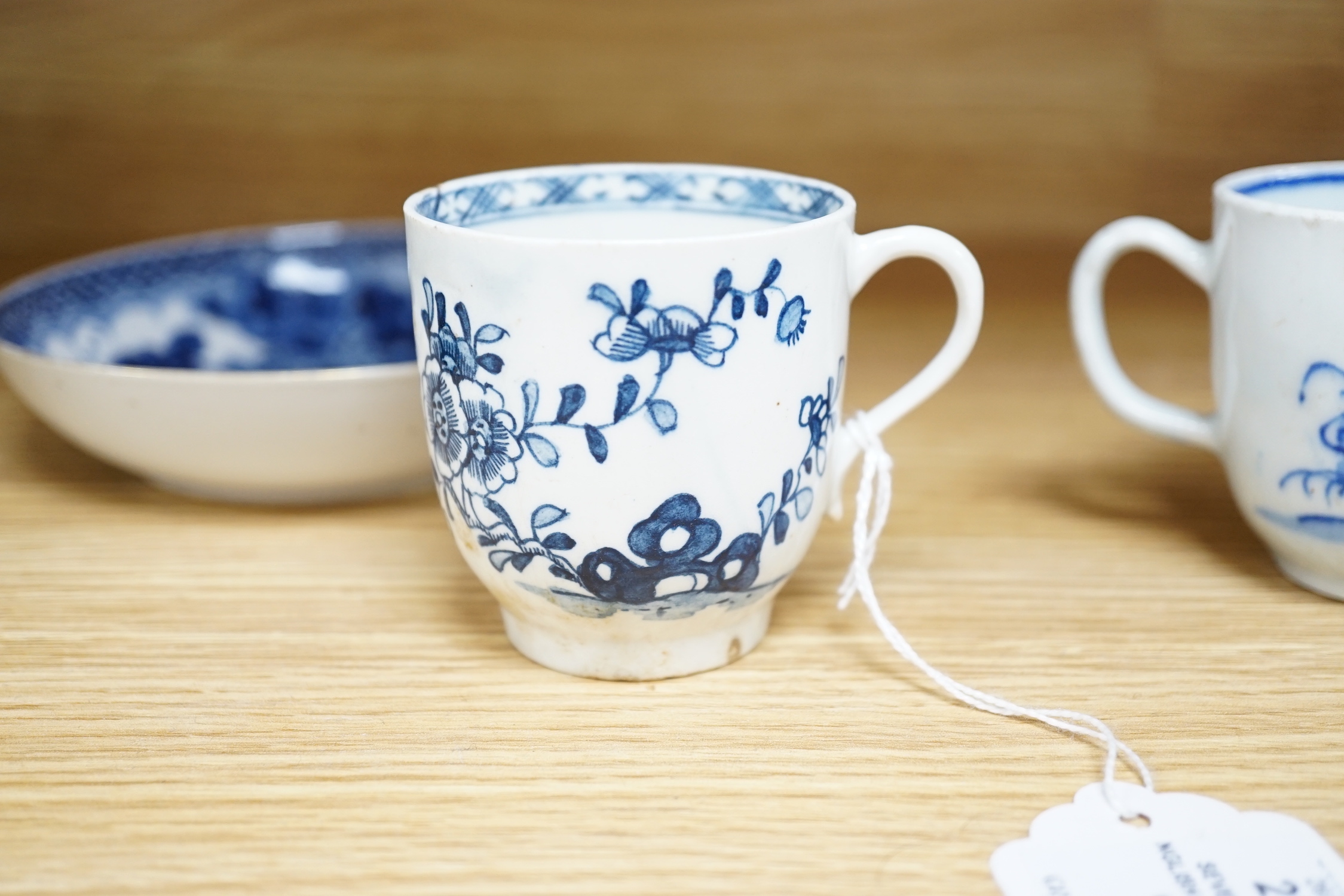 Seven various English porcelain coffee cups, including two Bristol enamelled with green floral sprays, two Bow painted in underglaze blue with a bird in a Chinese garden, and three Worcester/Bow in underglaze blue.